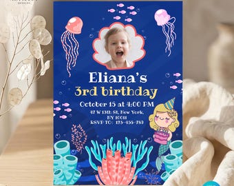Puede incluir: Una tarjeta de invitación de cumpleaños rectangular con fondo azul oscuro y la foto de un niño dentro de una concha rosa. El texto dice Eliana's 3rd birthday, October 15 at 4:00 PM, 47 W 13th St, New York, NY 10011, RSVP TO: 123-456-789.