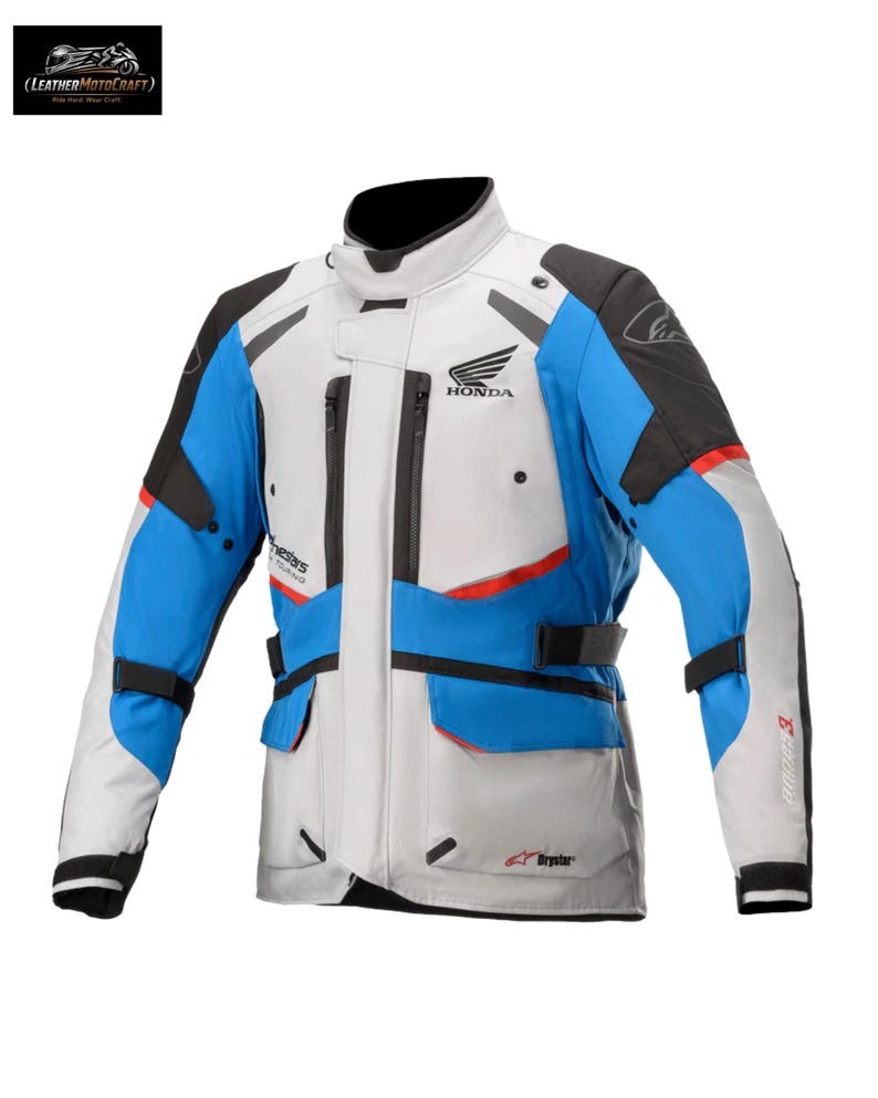 May include: A motorcycle jacket in white, blue, black, and red. The jacket has a Honda logo and multiple pockets. The jacket has a high collar and adjustable straps. The jacket is designed for motorcycle riding.