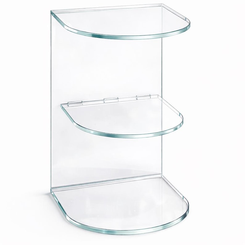 May include: Clear, three-tiered corner shelf made of glass. The shelves are semi-circular with rounded edges, and the back panel is rectangular. The design is minimalist and modern, suitable for displaying items in a bathroom or living space.