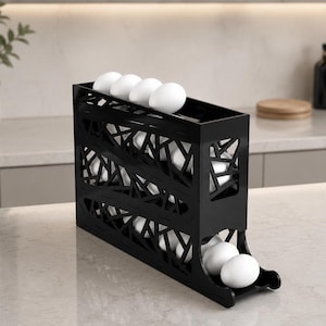 May include: Black egg holder with a geometric design, holding several white eggs. The holder is made of a dark material and has a tiered design for easy access. The kitchen item is on a marble countertop.