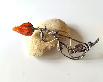 Broche con capullo de rosa y tallo de plata de ley oxidada en ámbar báltico y coñac