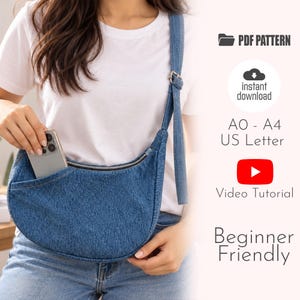Puede incluir: Un bolso bandolera de mezclilla azul en forma de media luna con cierre de cremallera superior y correa ajustable. El texto dice PDF PATTERN, instant download, AO - A4 US Letter, Video Tutorial y Beginner Friendly.