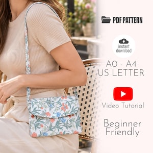 May include: A crossbody bag with a white base featuring a floral pattern of orange and blue flowers with green leaves. The text reads PDF PATTERN, instant download, AO - A4 US LETTER, Video Tutorial, and Beginner Friendly.