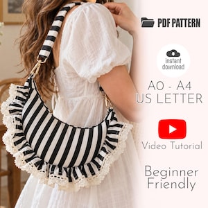 May include: A crescent-shaped shoulder bag featuring a black and white vertical stripe pattern, accented with white lace trim along the edges. The bag includes a matching striped shoulder strap with gold-tone hardware. Text includes PDF PATTERN, instant download, AO - A4 US LETTER, Video Tutorial, and Beginner Friendly.