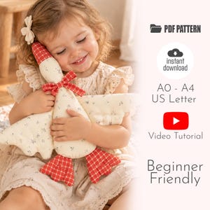 Könnte beinhalten: Ein Stoffgans-Spielzeug mit cremefarbenem Körper und kleinem dunklen Blumenmuster sowie Kopf, Füßen und einer Halsschleife aus rot-weiß kariertem Stoff. Der Text umfasst PDF PATTERN, instant download, AO - A4 US Letter, Video Tutorial, Beginner Friendly.