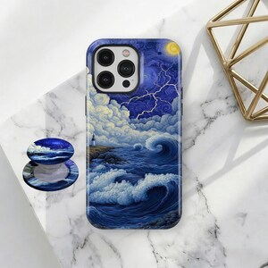 May include: A smartphone case and matching pop socket featuring a seascape design with a lighthouse, stormy waves, and a night sky with lightning. The case is dark blue with a glossy finish.