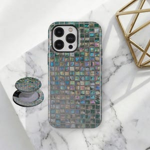 May include: A mosaic-patterned phone case and matching PopSocket. The case and PopSocket feature a square tile design with iridescent colors, including green, blue, and silver. The phone case is on a white marble surface.