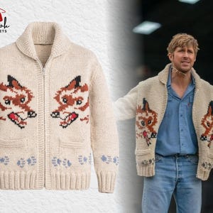 May include: Cream-coloured zip-up cardigan sweater with a shawl collar. The sweater features two fox-like animal designs on the front, with brown, black, and red details. The bottom hem has a blue floral pattern. The brand logo "Brook Jackets" is visible.