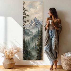 Puede incluir: Un cuadro vertical rectangular de arte mural que presenta una pintura de paisaje detallada con picos montañosos nevados sobre un bosque denso y brumoso de coníferas con pinos altos bajo un cielo nublado, colgado en una pared.