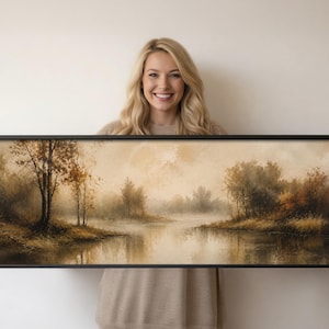 Könnte beinhalten: Ein Panoramagemälde in einem schwarzen Rahmen, das eine neblige Flusslandschaft mit Bäumen in Braun-, Beige- und gedämpften Orangetönen zeigt. Das Kunstwerk stellt ein ruhiges Gewässer dar, das das umliegende Laub unter einem weichen Himmel spiegelt.