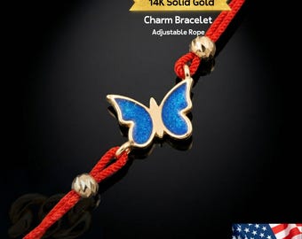 May include: A 14K solid gold charm bracelet with an adjustable red rope. The bracelet features a gold butterfly charm with blue enamel wings. The text "14K Solid Gold Charm Bracelet Adjustable Rope" is visible.