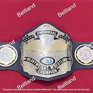 May include: A gold and silver heavyweight wrestling championship belt with a black leather strap. The center plate features an eagle design and the words "UNIVERSAL HEAVYWEIGHT WRESTLING CHAMPION". Additional plates with wrestling figures and heraldic lions are also visible.