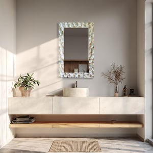 Decorative glass mirror displayed above a wooden console in a bright neutral living room interior