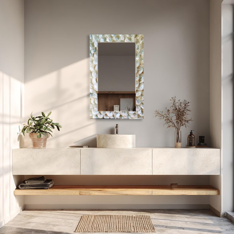 Decorative glass mirror displayed above a wooden console in a bright neutral living room interior