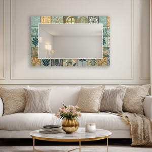 Puede incluir: Un espejo de pared rectangular con un borde decorativo compuesto por varios azulejos cuadrados. Los azulejos muestran una mezcla de patrones botánicos, geométricos y abstractos en tonos azul verdoso, amarillo mostaza, blanco y gris oscuro.