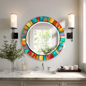 Peut inclure: Un miroir mural rond doté d'un cadre décoratif avec un motif de vitrail vibrant dans des tons de bleu sarcelle, orange, jaune et rouge. Le cadre se compose de panneaux de verre colorés segmentés disposés en cercle autour du centre réfléchissant.