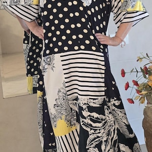 May include: A patchwork maxi dress featuring a mix of patterns, including polka dots, stripes, and floral prints. The dress incorporates black, white, and yellow panels, with lace detailing at the neckline. The sleeves are short and wide.
