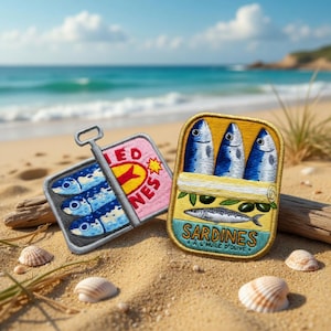 Può includere: Toppe ricamate di scatole di sardine su una spiaggia sabbiosa. Una toppa è rosa con la scritta "SARDINES" e una stella gialla. L'altra è gialla con tre pesci blu e la scritta "SARDINES A L'HUILE D'OLIVE".