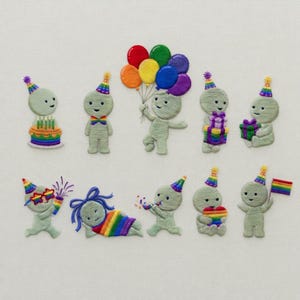 May include: An embroidered design showing several whimsical figures in party hats, each with a unique celebratory element. Some figures hold balloons, gifts, or a rainbow flag, while others are near a cake or wearing rainbow attire. The figures are light green.