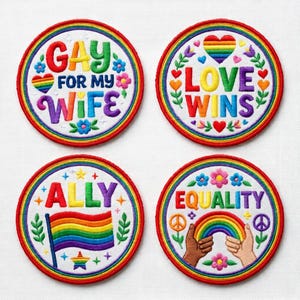 May include: Four embroidered patches with rainbow and floral designs. The patches feature the phrases "GAY FOR MY WIFE", "LOVE WINS", "ALLY", and "EQUALITY". Each patch has a rainbow border and various symbols.
