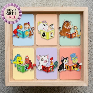 May include: A wooden display box containing six rectangular cards, each featuring a pair of colourful cartoon characters reading a book. The cards depict scenes with Aladdin, Beauty and the Beast, The Lion King, The Little Mermaid, Moana, and Pinocchio.