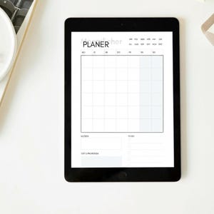 Könnte beinhalten: Ein schwarzes Tablet, das eine minimalistische Planerseite mit dem Wort "PLANER" und dem Wort "her" über einem Raster anzeigt. Der Planer enthält Abschnitte für Notizen und To-Do-Listen, mit weißem Hintergrund.