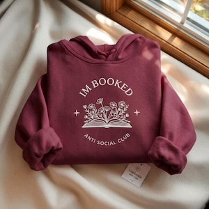 Könnte beinhalten: Eine weiße Keramik-Tasse mit schwarzem Henkel und dem Text "But First, Coffee" in handschriftlichem Stil. Die Tasse steht auf einer weißen Oberfläche. Die Tasse ist 10 cm hoch.