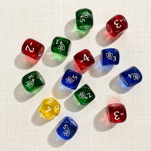 Pode incluir: Um conjunto de doze dados translúcidos de seis lados nas cores vermelho, verde, azul e amarelo. Cada dado apresenta números brancos impressos que variam de -5 a +7 e um pequeno ícone de escudo. Os dados estão espalhados pela imagem.