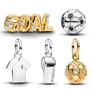 Könnte beinhalten: Eine Sammlung von Fußball-Anhängern und -Anhängern. Enthält einen goldenen "GOAL"-Anhänger, einen Fußball-Charm mit schwarzen Akzenten, einen Schiedsrichter-Trikot-Charm, einen Pfeifen-Charm und einen goldenen Fußball-Charm mit einem Diamanten.