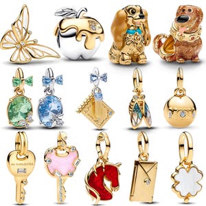 May include: A collection of gold-toned charms, including a butterfly, apple, dog, and a dog-like character. Other charms include a key, a key with a pink heart, a horse, an envelope, a four-leaf clover, and gemstone pendants.