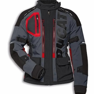 May include: A black, grey, and red motorcycle jacket with the word "DUCATI" printed on the front. The jacket features multiple pockets, zips, and adjustable straps. It has a high collar and reinforced shoulders.