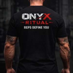 May include: Black t-shirt with the text "ONYX RITUAL REPS DEFINE YOU" in white and red. The image shows the back of a person wearing the shirt, with visible arm muscles and tattoos. The shirt is a crew neck.