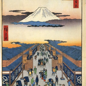 May include: A woodblock print depicting a bustling street scene in Japan. The street is lined with shops and stalls, and people are walking and shopping. In the distance, Mount Fuji rises above the clouds. The print is titled "The Street of Edo" in Japanese.