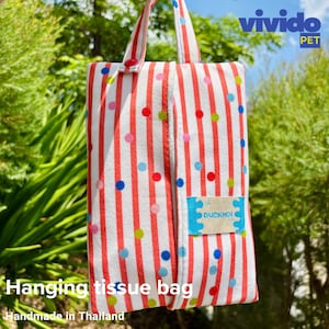 May include: A hanging tissue bag featuring red and white vertical stripes and multi-coloured polka dots. The bag has a handle and a small tag with the text "DUCKMOI". The text "Hanging tissue bag" and "Handmade in Thailand" are also visible.