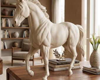 Puede incluir: Una estatua de caballo color crema con musculatura detallada se alza sobre una mesa de madera. La escultura es una representación clásica de un caballo, con una melena y cola fluidas. Un adorno decorativo para el hogar.