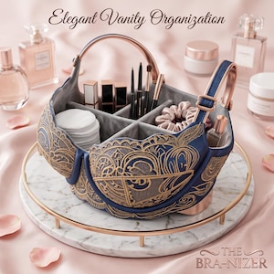 May include: A navy blue vanity organizer shaped like a bra, with gold embroidery and a handle. The organizer sits on a marble tray and holds makeup, brushes, and cotton pads. The text "Elegant Vanity Organization" is at the top.