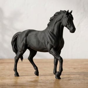 Peut inclure: Figurine de cheval noir en position de marche. La sculpture pr&eacute;sente une crini&egrave;re et une queue d&eacute;taill&eacute;es, sur fond neutre. Le cheval est de couleur unie et semble &ecirc;tre fait d'un mat&eacute;riau mat.