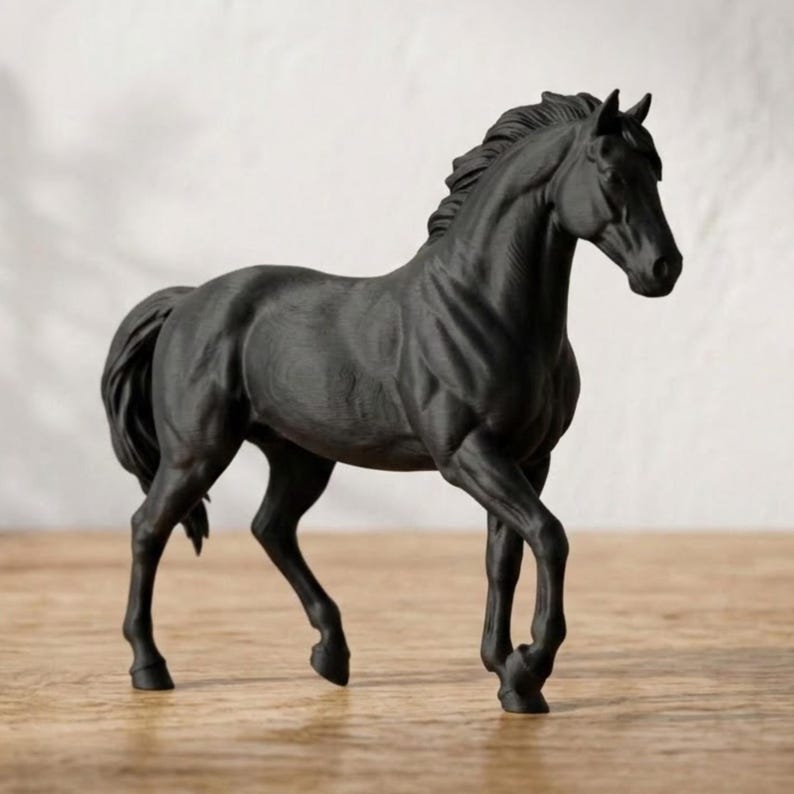 Peut inclure: Figurine de cheval noir en position de marche. La sculpture pr&eacute;sente une crini&egrave;re et une queue d&eacute;taill&eacute;es, sur fond neutre. Le cheval est de couleur unie et semble &ecirc;tre fait d'un mat&eacute;riau mat.