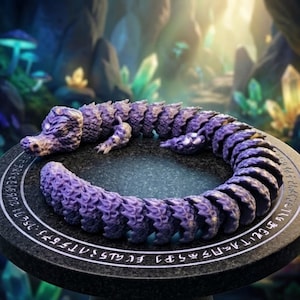May include: A purple articulated crocodile figurine with a segmented, flexible body and textured scales. The creature is coiled in a circle on a dark, circular stone-like platform featuring a white circular border with etched runic symbols.
