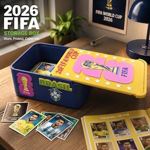 May include: A blue plastic storage box with a yellow lid featuring the text 2026 FIFA WORLD CUP and a trophy graphic. The box is decorated with FIFA and Brasil stickers. Several soccer player trading cards and a sticker album are displayed nearby.