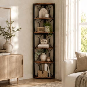 Op de afbeelding: Een hoge hoekkast met vijf niveaus, voorzien van een zwart metalen frame met gebogen, cirkelvormige zijsteunen en donkerbruine houten planken. De kast is gevuld met diverse decoratieve items, waaronder boeken, een kleine radio, planten en opbergdozen.