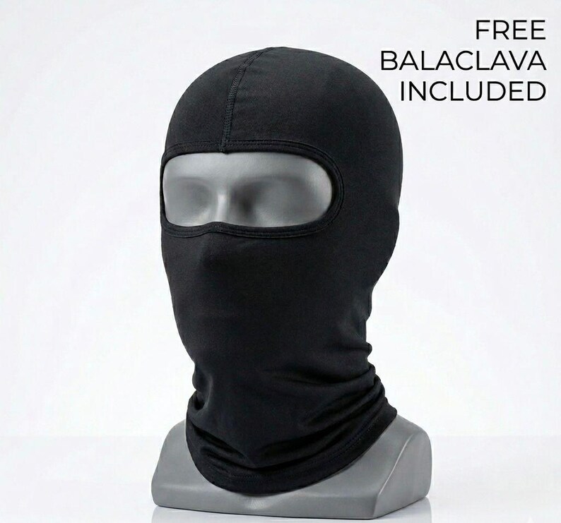May include: A solid black balaclava made of fabric, featuring a single large eye opening. The balaclava is displayed on a gray mannequin head. The text FREE BALACLAVA INCLUDED is printed in black on the upper right side of the image.