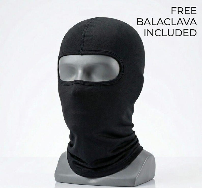 May include: A black balaclava displayed on a mannequin head. The balaclava covers the entire head and neck, with an opening for the eyes. The text "FREE BALACLAVA INCLUDED" is visible in the upper right corner.