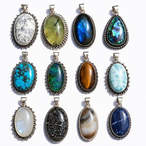 May include: A collection of twelve oval-shaped pendants set in silver-toned metal frames. Each pendant features a unique gemstone, including white dendritic stone, translucent green, iridescent blue, abalone, turquoise, dark green, tiger eye, and blue larimar.