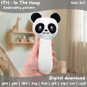 May include: A white and black panda bear rattle with a long handle. The rattle has black ears and eyes, and a smiling face. The text "ITH - In The Hoop Embroidery pattern" and "Digital download" are visible. The size is 5x7 inches.