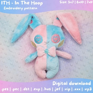 May include: A plush bunny with a split design, half pink and half blue, featuring heart-shaped eyes and a bow tie. The text "ITH - In The Hoop Embroidery pattern" is at the top. The text "Digital download" is at the bottom.
