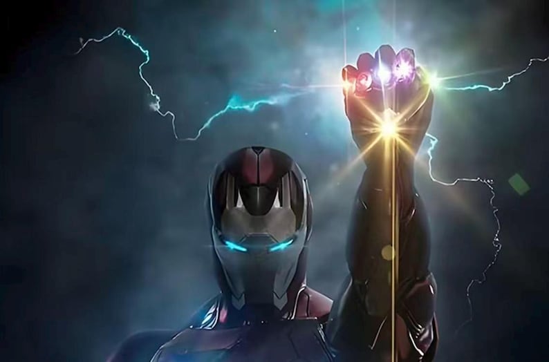 May include: Iron Man's helmet and arm, with the Infinity Gauntlet, are featured in this image. The gauntlet glows with the colors of the Infinity Stones. Lightning bolts and a bright light emanate from the gauntlet.