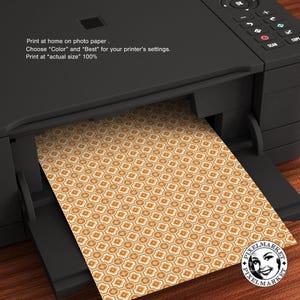 May include: A printer with a sheet of paper with a geometric pattern in shades of orange and white. The text on the printer reads: "Print at home on photo paper. Choose "Color" and "Best" for your printer's settings. Print at "actual size" 100%"