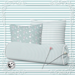 Peut inclure: Trois coussins d&eacute;coratifs en tissu vichy bleu clair et blanc. Les coussins sont dispos&eacute;s sur un fond ray&eacute; bleu clair et blanc. Les coussins pr&eacute;sentent diff&eacute;rents motifs, dont un motif de lapin et de lune, un motif en losange et un motif vichy.