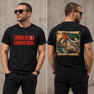 Puede incluir: Una camiseta negra de manga corta con el texto rojo TRIBULATION COMING SOON y una cruz blanca en el frente. La parte posterior muestra un gráfico de un pie pisando una serpiente sobre un globo terráqueo, enmarcado por un borde de pergamino beige.